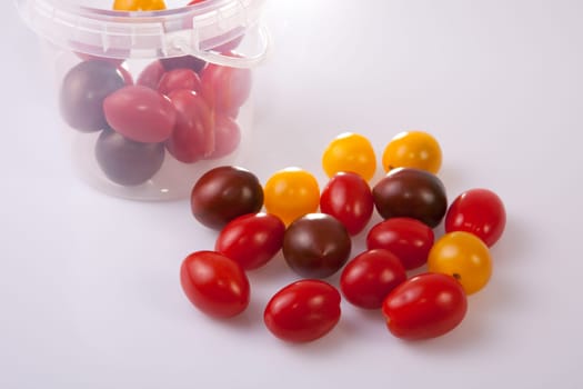 Bucket and colorful cherry tomatoes. Isolated over white background