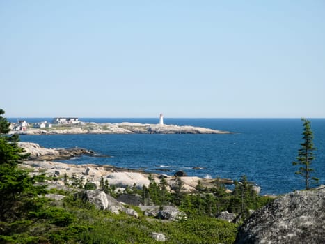 View over a bay of the lighthouse of Peggys Cove,Nova Scotia,Canada.
