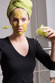 Attractive young woman with spots using a facial avocado mask