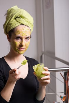 Attractive young woman with spots using a facial avocado mask