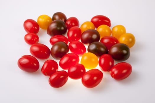 Handful of colorful cherry tomatoes. Isolated over white background