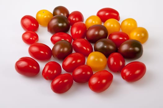 Handful of colorful cherry tomatoes. Isolated over white background