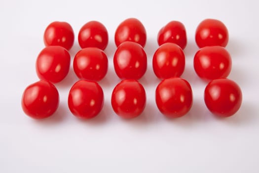 Red shiny cherry tomatoes. Isolated over white background