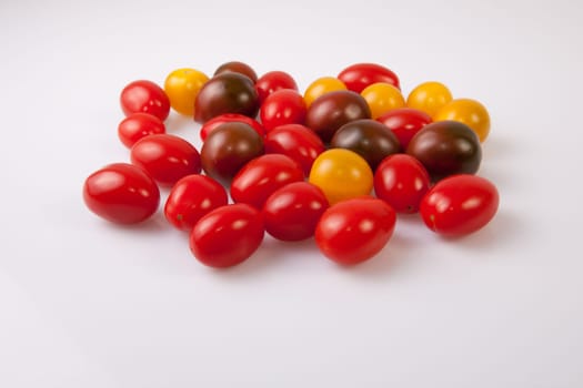 Handful of colorful cherry tomatoes. Isolated over white background