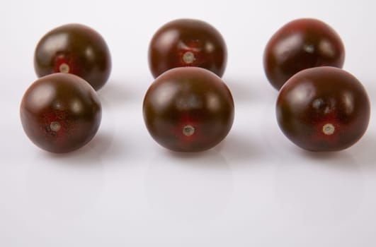 Dark green cherry tomatoes. Isolated over white background