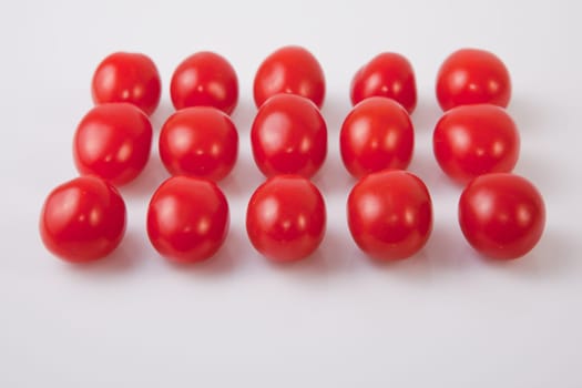 Red shiny cherry tomatoes. Isolated over white background