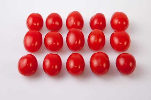 Red shiny cherry tomatoes. Isolated over white background