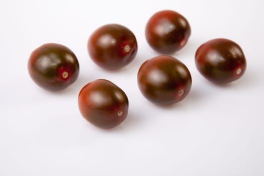 Dark green cherry tomatoes. Isolated over white background