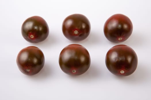 Dark green cherry tomatoes. Isolated over white background