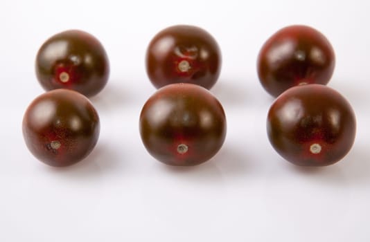 Dark green cherry tomatoes. Isolated over white background