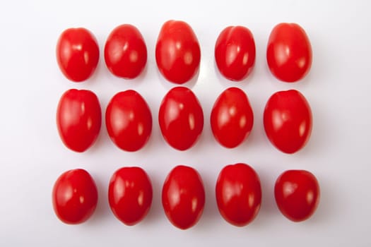 Red shiny cherry tomatoes. Isolated over white background