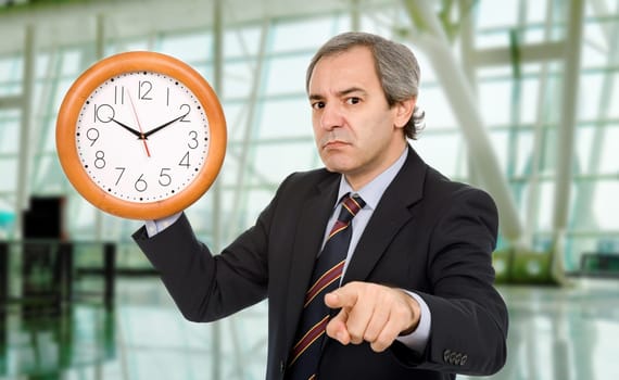 mature mad business man with a clock