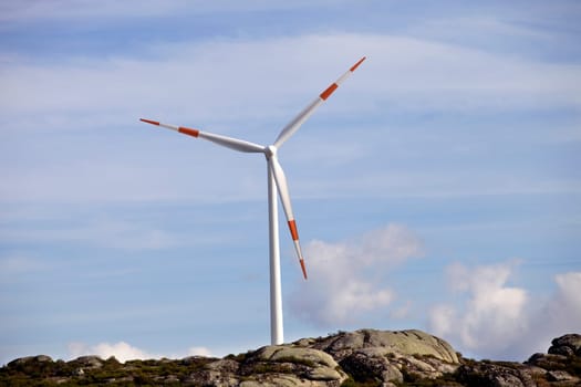 white wind turbine in the top of the mountain