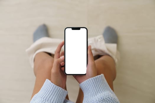 Woman holding a phone while using the toilet, Mock up phone  white screen display in hand
