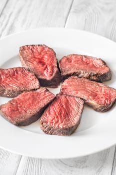Tender fillet mignon steak, perfectly cooked, sliced, and elegantly presented on a plate