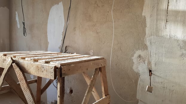 Repair in the apartment. Grunge wooden staircase. The concept of registration of the apartment. bench for painting the ceiling
