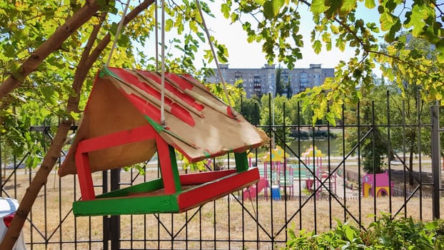 Handmade bird feeders made of wood in a city park. Bird house
