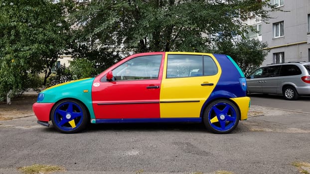 Ukraine, Kiev - March 27, 2020: Volkswagen Golf 4 model with a hatchback body with multi-colored body parts. Funny and bright car in red, blue, yellow. car painted in different colors.