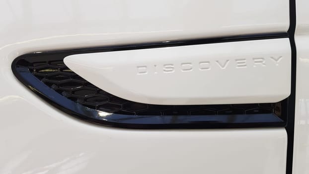 Ukraine, Kiev - March 27, 2020: new white Land Rover Discovery Sport 2019. Side view of the wing and part of the door with the inscription. Medium SUV.