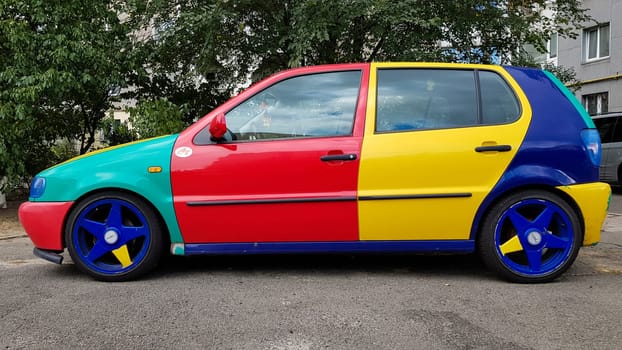 Ukraine, Kiev - March 27, 2020: Volkswagen Golf 4 model with a hatchback body with multi-colored body parts. Funny and bright car in red, blue, yellow. car painted in different colors.