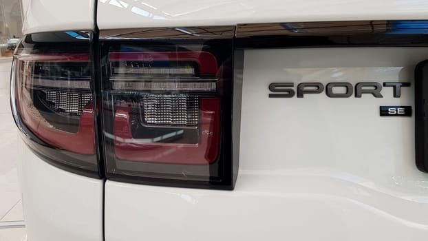 Ukraine, Kiev - March 27, 2020: Land Rover Discovery Sport shiny modern white car at the exhibition. Body, headlights close-up, rear and front view, chrome grille, car logo