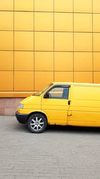 Ukraine, Kiev - March 27, 2020: Yellow Transporter in yellow on a background of a yellow building