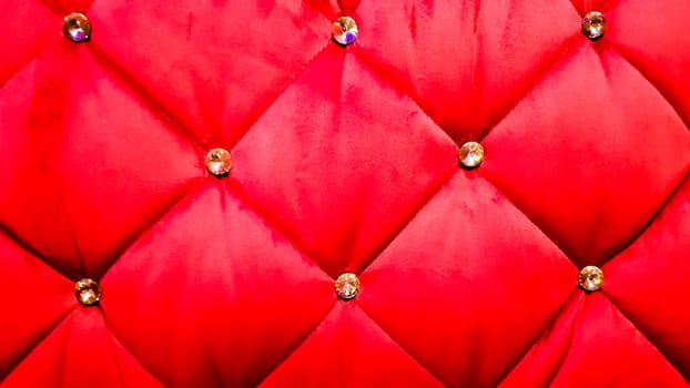 back of a red sofa. Red fabric texture background, Chesterfield style decoration with buttons, retro fabric. Retro diamond-shaped soft style fabric decorate with buttons. red velvet background.