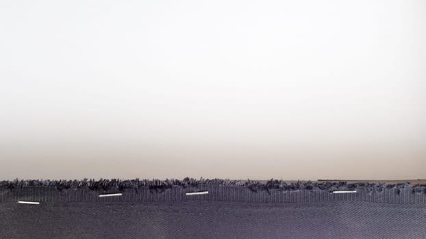 White background with a black fabric stripe punched with staples to a wooden plank. Abstract background with copy space