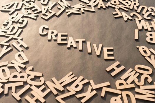 Creative Word In Wooden Cube Alphabet Letters Top View On A rustic paper Background.