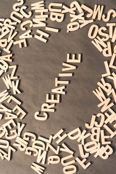 Creative Word In Wooden Cube Alphabet Letters Top View On A rustic paper Background.