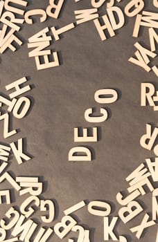 Deco Word In Wooden Cube Alphabet Letters Top View On A rustic paper Background.