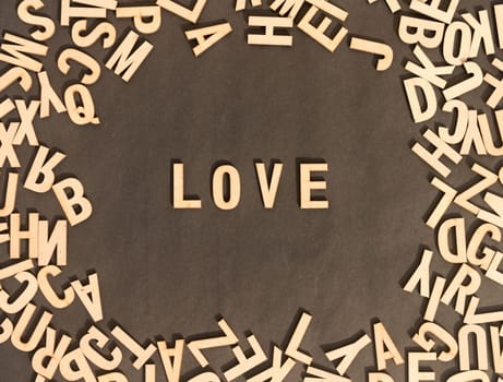Love Word In Wooden Cube Alphabet Letters Top View On A rustic paper Background.
