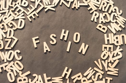 Fashion Word In Wooden Cube Alphabet Letters Top View On A rustic paper Background.