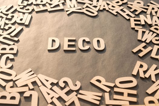 Deco Word In Wooden Cube Alphabet Letters Top View On A rustic paper Background.