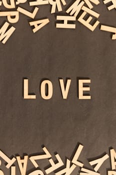 Love Word In Wooden Cube Alphabet Letters Top View On A rustic paper Background.