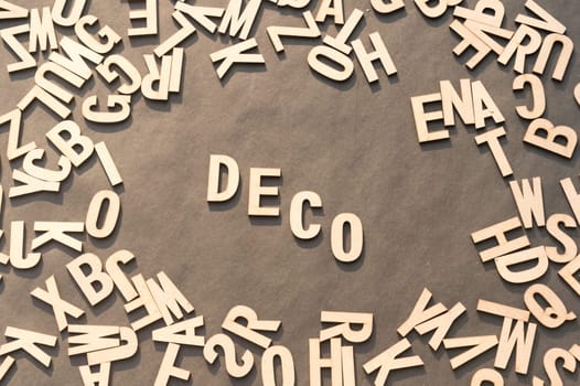 Deco Word In Wooden Cube Alphabet Letters Top View On A rustic paper Background.