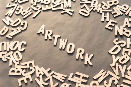 Artwork Word In Wooden Cube Alphabet Letters Top View On A rustic paper Background.