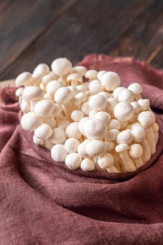 A delicate cluster of bunapi-shimeji mushrooms resting in textile