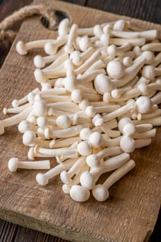 A delicate cluster of bunapi-shimeji mushrooms resting on a wooden surface