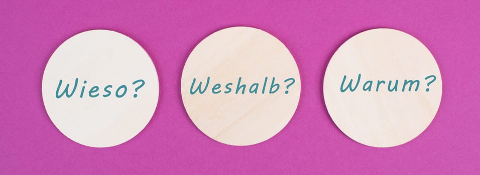 The german words for why are standing on circels, pink colored background, asking questions