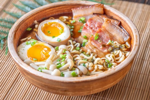 A steaming bowl of ramen filled with noodles, tender pork, and savory toppings