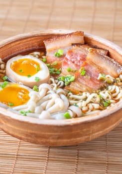 A steaming bowl of ramen filled with noodles, tender pork, and savory toppings