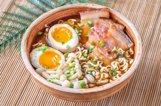 A steaming bowl of ramen filled with noodles, tender pork, and savory toppings
