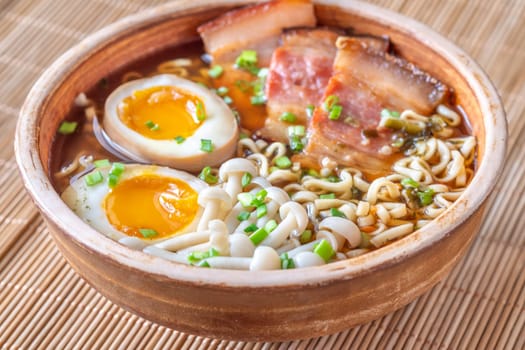 A steaming bowl of ramen filled with noodles, tender pork, and savory toppings