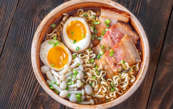 A steaming bowl of ramen filled with noodles, tender pork, and savory toppings