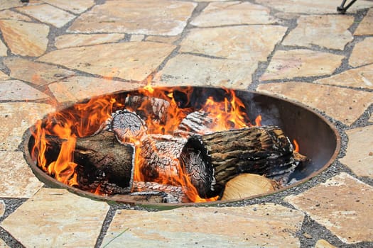 A sucken firepit with a fire burning.