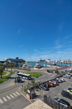 Civitavecchia. Italy - January 26, 2025: Civitavecchia port on a sunny day, showcasing cruise ships, yachts, and a parking area. Palm trees and blue skies enhance the travel and tourism appeal.