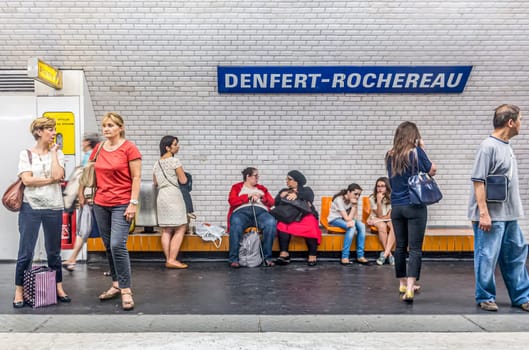 Paris, France - June 12, 2015:  people wait in the Metro station for next arriving train.