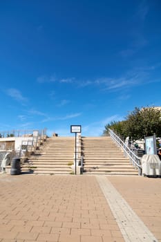 Civitavecchia. Italy - January 27, 2025: Stone steps ascending to the Giovanni Paolo II terrace in Civitavecchia, Italy. The scene is bright and inviting, perfect for travel and architecture themes.