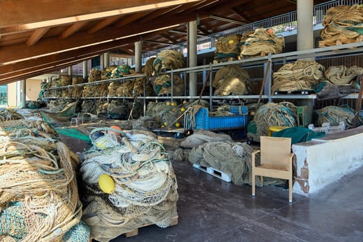 A harbor-side storage area for large fishing nets and equipment. The setup is part of the fishing infrastructure that supports coastal livelihoods.